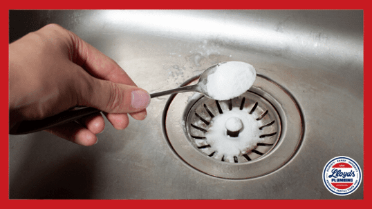 Pouring baking soda into the kitchen sink drain