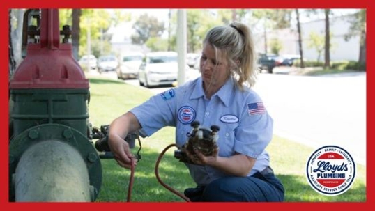 A woman using a backflow testing device on a backflow prevention system